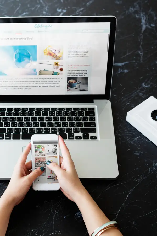 A laptop showing a blog page beside a phone showing the same site as a photo grid.