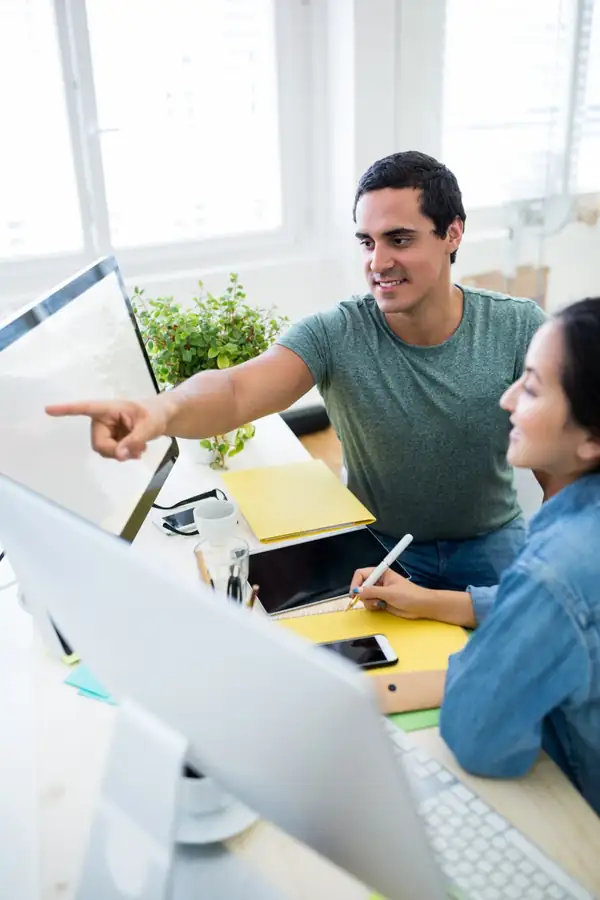 A small team reviewing a website design on a monitor.